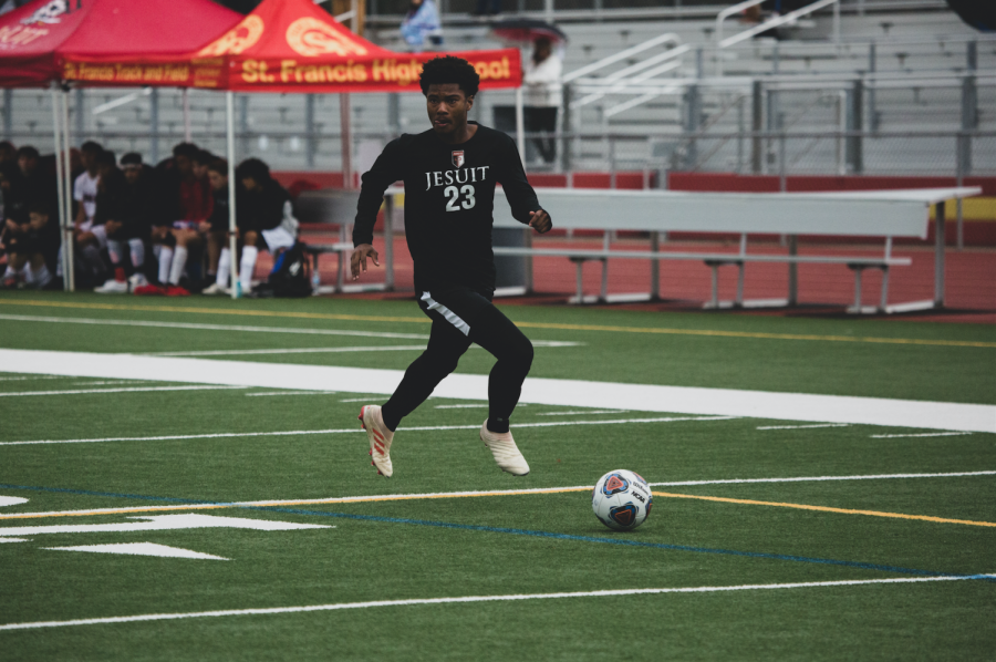 Jesuit striker Elijah Beverly 21 dribbling the soccer ball in a home game last season.