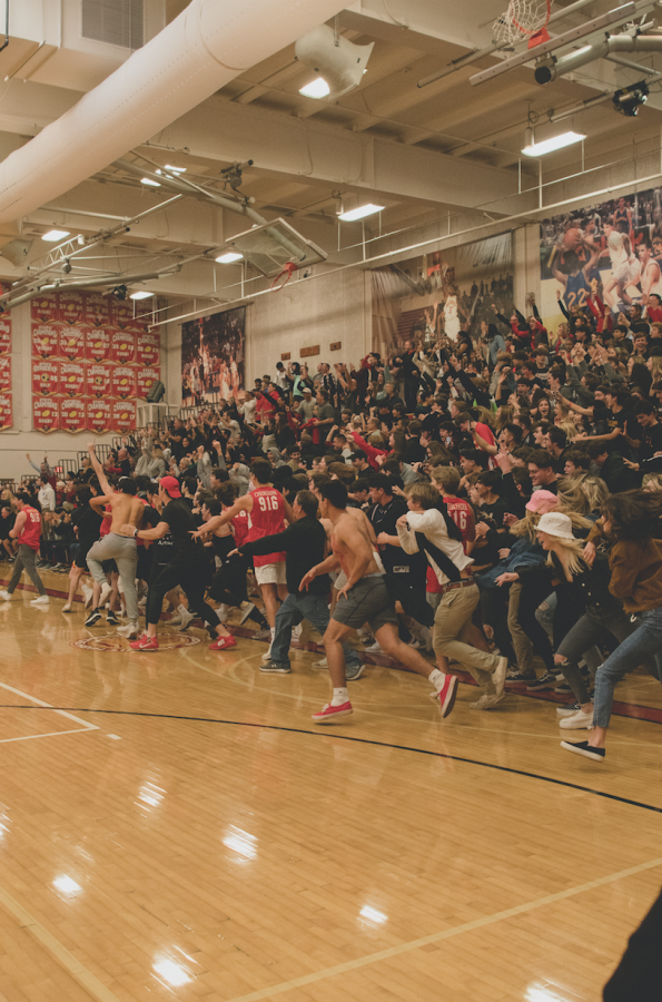 Jesuit High School students rush the court following Jesuits victory over Christian Brothers High School.