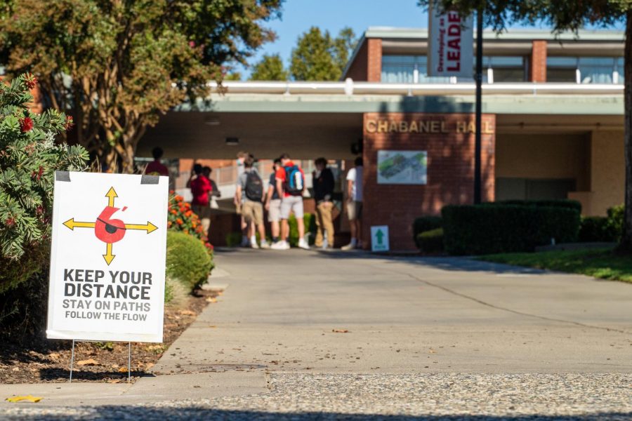 A sign reminds students to keep their distance and follow the clockwise campus flow during Junior Training for the Return to Campus
at Jesuit High School on Oct. 13, 2020.  