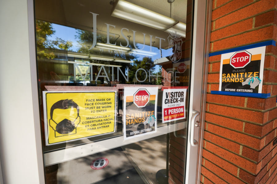 Jesuit High School Sacramento’s Main Office is decorated with numerous health safety posters reminding entrants to wear a face covering, sanitize properly, and remain distant from each other when entering the building. Taken on Tuesday, Oct. 13, 2020, in Carmichael, California.